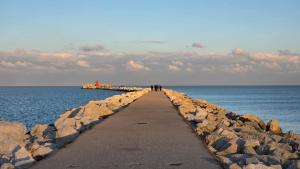 a group of people walking on a pier in the ocean at La Margherita in Ortona