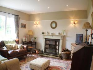 a living room with a couch and a fireplace at Foxhill House in Ledbury