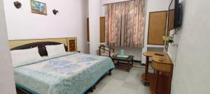 a bedroom with a bed and a desk and a television at Hotel Taj Plaza, Just a 5-minute walk from the Taj Mahal 600 meters in Agra +94 photos
