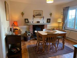 a living room with a table and a fireplace at Foxhill House in Ledbury
