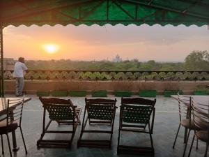 a man standing on a roof looking at the sunset at Hotel Taj Plaza, Just a 5-minute walk from the Taj Mahal 600 meters in Agra