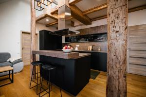 a kitchen with a black island with a counter top at Turistka Loft in Kutná Hora