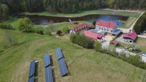 an aerial view of a house with solar panels on a field at Pensjonat Dolina Wierzby in Olsztyn