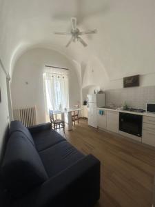 a living room with a blue couch and a kitchen at Guest house Novecento in Palo del Colle