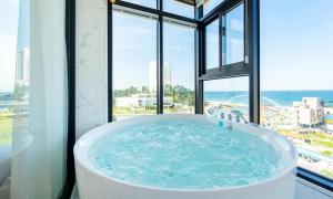 a large bath tub in a room with windows at Gangneung Skaria Poolvilla in Gangneung +41 photos