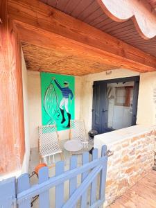 a patio with two chairs and a table and a painting at Charmant gite en pierre in Gratot