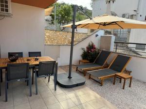 a patio with an umbrella and a table and chairs at Lorenzo apartment in Milna +8 photos