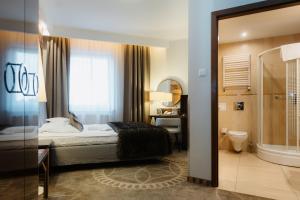 a bedroom with a bed and a bathroom with a shower at Sandra Spa Karpacz & Aquapark in Karpacz