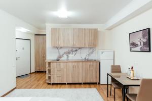 a kitchen with wooden cabinets and a table in a room at Apart Hotel Anastasia in Chişinău