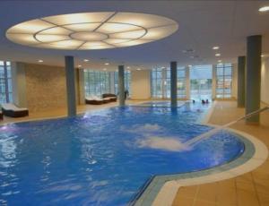 a large swimming pool in a building with a ceiling at Pokoje Hotel Diva 200 metrów do plaży in Kołobrzeg
