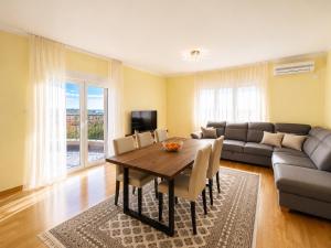 a living room with a table and a couch at Krimovica Sunset Spacious Apartment with Sea View and Pool in Krimovice