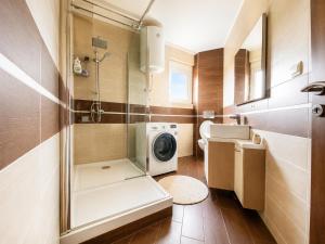 a bathroom with a washing machine and a washer at Krimovica Sunset Spacious Apartment with Sea View and Pool in Krimovice +18 photos