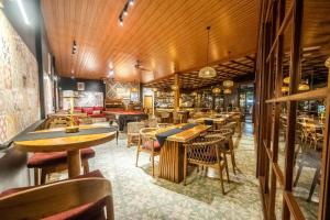 a restaurant with wooden ceilings and tables and chairs at Sake Bali Suites in Tegalalang