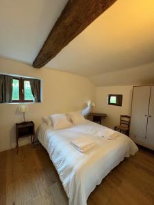 a bedroom with a bed with white sheets and a window at Gîte Les Moreaux in Saint-Amand-en-Puisaye