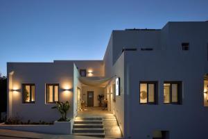 a white house with a hallway in front of it at Paros Cape Suites in Naousa