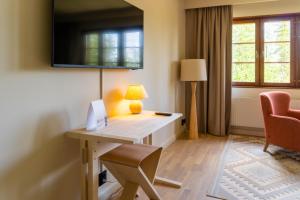 a room with a desk with a lamp and a chair at Storhogna Högfjällshotell & Spa in Storhågna