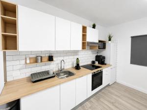 a kitchen with white cabinets and a sink at Noalys Entre Mar y Valle in Agaete