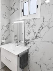 a white bathroom with a sink and a mirror at Noalys Entre Mar y Valle in Agaete +24 photos