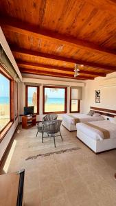 a bedroom with two beds and a couch and a table at Matarma Bay Hotel in Ras Sedr