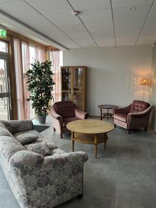 a living room with couches and a table and chairs at Hotell Vänersborg in Vänersborg +37 photos