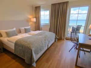 a hotel room with a bed and a view of the ocean at Strandhotel Miramar in Timmendorfer Strand +68 photos