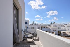 two chairs on a balcony with a view of the city at Paros Cape Suites in Naousa +101 photos