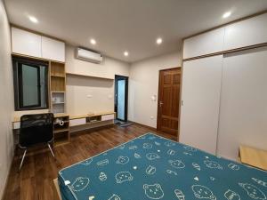 a bedroom with a bed and a desk in it at Sơn Tài in Hanoi