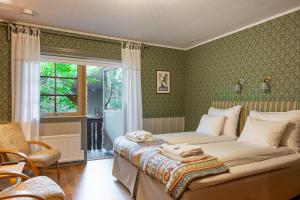 a bedroom with a bed and a chair and a window at Storhogna Högfjällshotell & Spa in Storhågna +44 photos