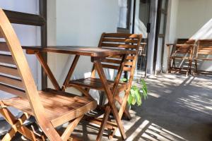a wooden table and chairs sitting on a porch at African Sands Guesthouse in Bloemfontein