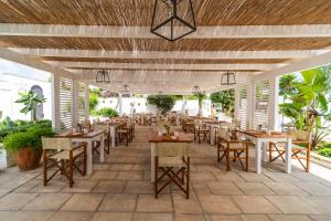 a restaurant with wooden tables and chairs on a patio at Tenuta Centoporte in Otranto