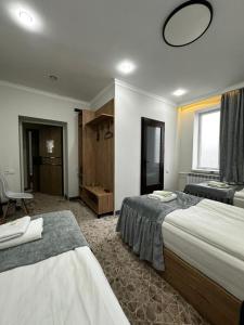 a hotel room with two beds and a mirror at Asmanguesthouse in Naryn +9 photos