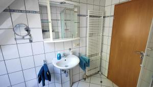 a bathroom with a sink and a mirror at 4 Sterne Ferien Martens in Cuxhaven +14 photos
