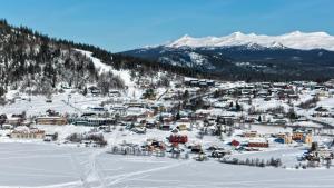 a town in the snow with mountains in the background at Morgondoppet - Olen Funäsdalen in Funäsdalen