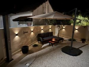 a patio with a couch and an umbrella and a table at Lorenzo apartment in Milna