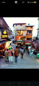 a group of people walking down a city street at HOTEL MALOOK A blink away from Mall Road in Shimla