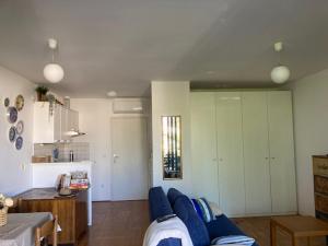a living room with a blue couch and a kitchen at 20 Koraka in Klenovica