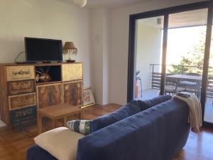 a living room with a blue couch and a television at 20 Koraka in Klenovica