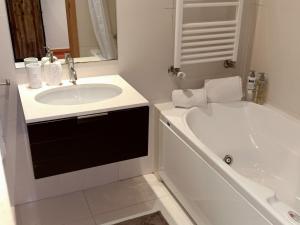 a white bathroom with a sink and a tub at Pacos Beach House in Lavra +14 photos