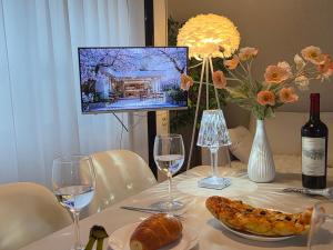 a table with wine glasses and a plate of food at 스미다 stay in Bucheon