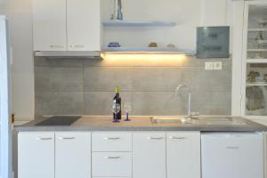 a kitchen with a sink and a bottle of wine at Seafis Boathouse Klima in Klima