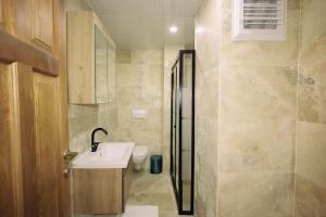 a bathroom with a sink and a toilet and a shower at Castle Stone House in Uçhisar +36 photos