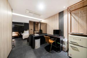 a room with a desk with a computer and a bedroom at Yeoksam Lumiere Hotel in Seoul