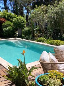 a swimming pool with chairs and plants on a deck at La Vagabonde in Saint-Tropez