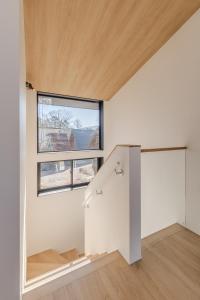 an empty room with a staircase and a window at Kuro Hakuba in Hakuba