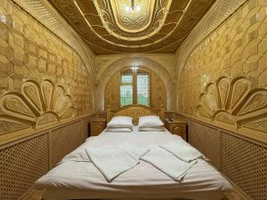a bedroom with a large bed with a ceiling at Turkiston Hotel in Namangan