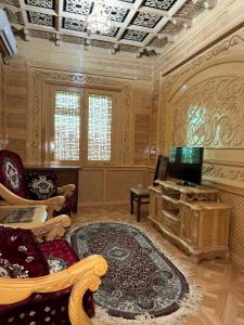a living room with a tv and a couch and a table at Turkiston Hotel in Namangan
