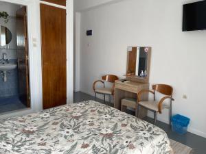 a bedroom with a bed and a desk and a sink at Platanos Rooms in Agia Marina