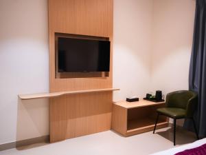 a room with a tv and a desk and a chair at K Hotels by SYN in Bangalore