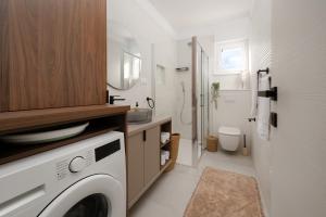 a laundry room with a washer and dryer in it at Lejla Garden Apartment in Podstrana +32 photos