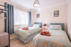 a bedroom with two beds with stuffed animals on them at Boyd’s Bungalow, Lowestoft in Lowestoft